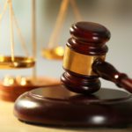 A judge 's gavel and scale of justice on top of a table.