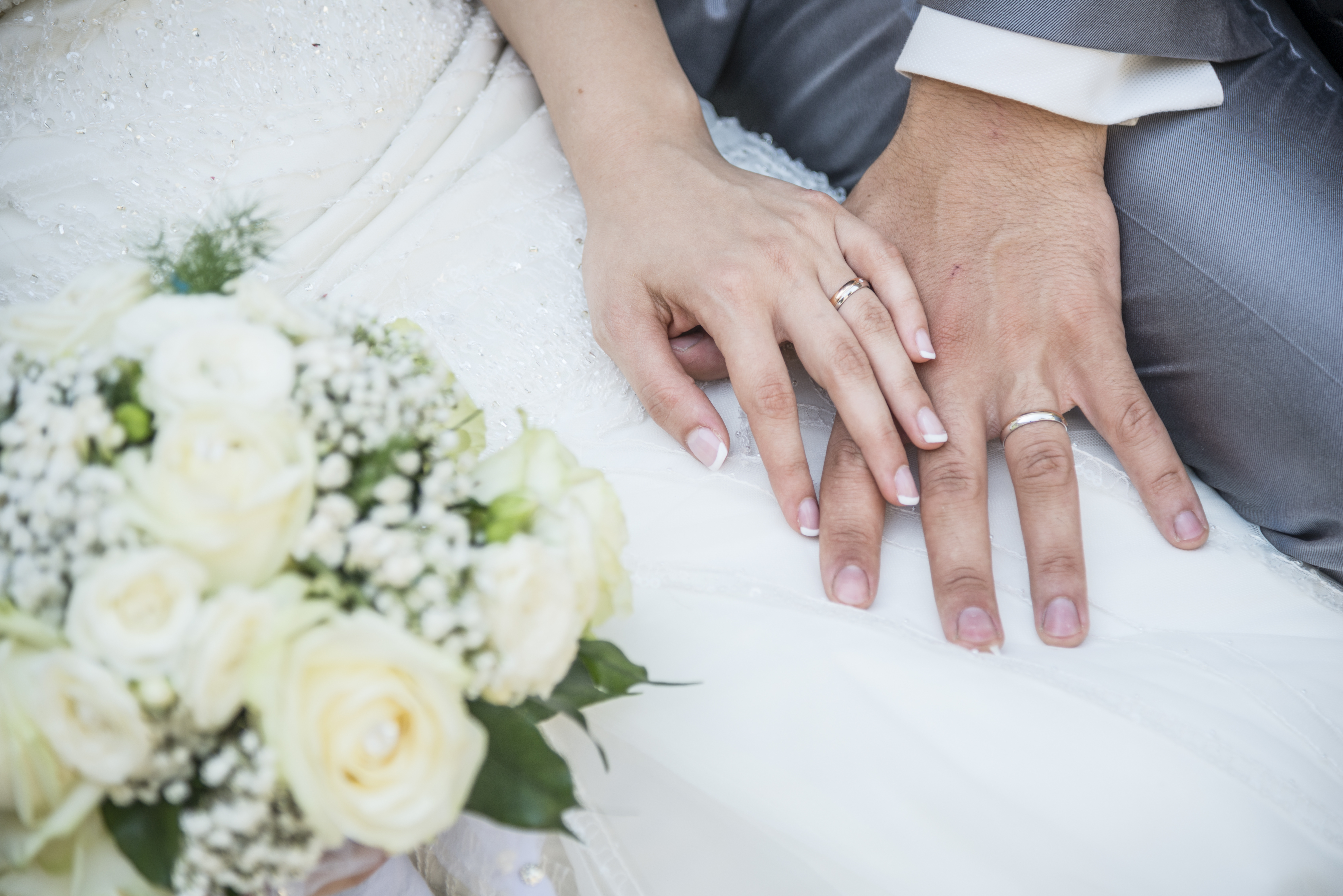 A close up of two hands with wedding rings