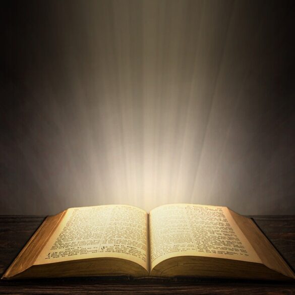 A book is lit up by the light of an open window.