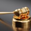 A gold gavel sitting on top of a metal object.