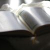 A book is open and lit up by the sun.