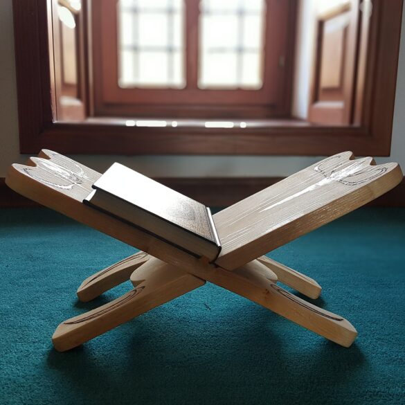 A book is sitting on the ground in front of an open window.