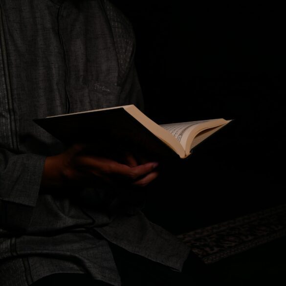 A person holding an open book in their hands.