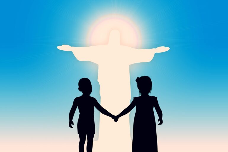 A couple of people holding hands in front of the statue.