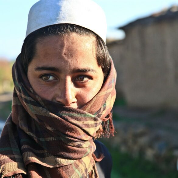 A woman with a white hat and scarf covering her face.