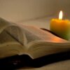 A candle and an open book on the table