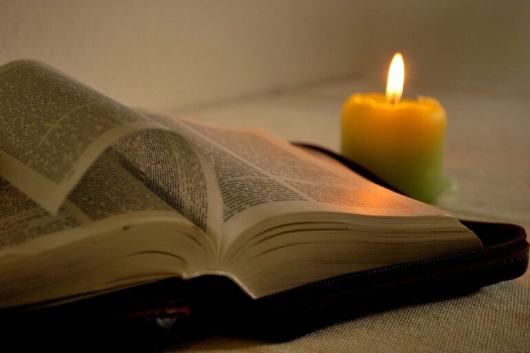 A candle and an open book on the table