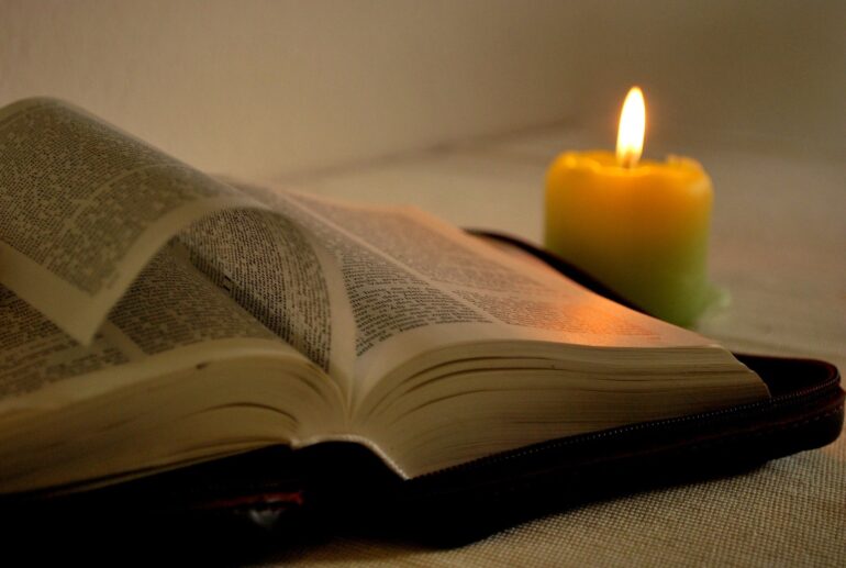 A candle and an open book on the table