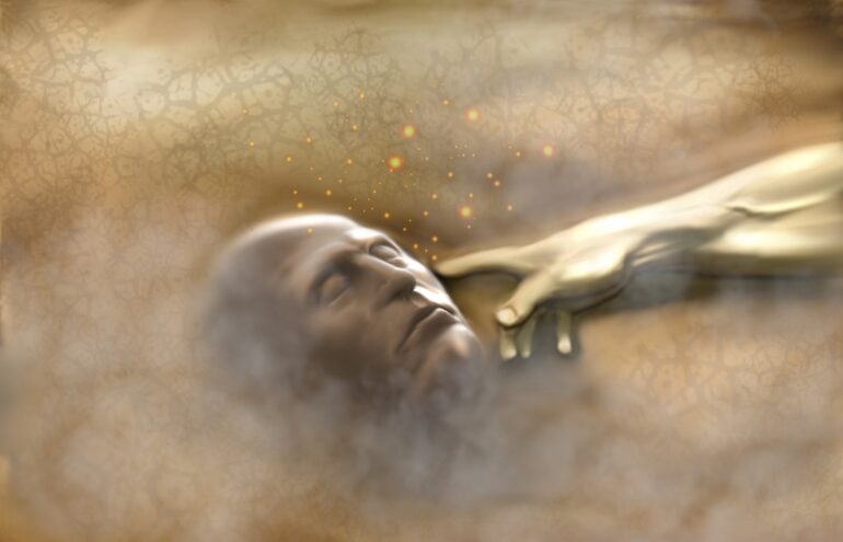A man laying in the sand with his hand extended.